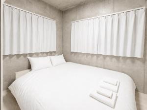 a bedroom with a white bed and a window at NEW OPEN!! SLEEPLAB 池袋 -ikebukuro- in Tokyo