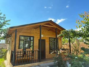a small log cabin with a porch and a fence at Мачу Пикчу in Cholpon-Ata
