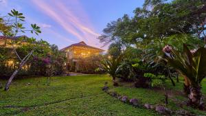 a house in a garden with trees and a lawn at Villas Serenidad in Puerto Viejo