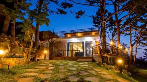 a house in the woods at night with lights at Goseong Pinetree Pension in Goseong