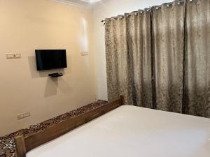a bedroom with a bed and a flat screen tv at p&q's guest house in Srinagar