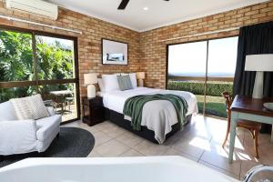 a bedroom with a bed and a balcony at Maleny Views Motel in Maleny