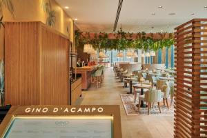 a restaurant with a bar and tables and chairs at INNSiDE by Meliá Manchester in Manchester