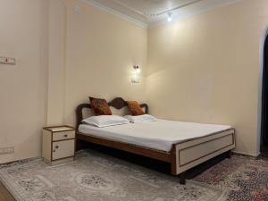 a bedroom with a bed with white sheets and pillows at p&q's guest house in Srinagar