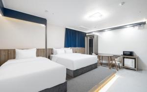 a hotel room with two beds and a table at Brown Dot Hotel Daecheon Beach, Boryeong in Boryeong +46 photos