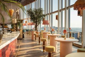 a restaurant with tables and chairs and large windows at INNSiDE by Meliá Amsterdam in Amsterdam