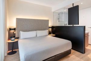 a bedroom with a large bed and a table at INNSiDE by Meliá Amsterdam in Amsterdam