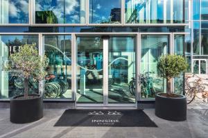 two potted trees in front of a building at INNSiDE by Meliá Amsterdam in Amsterdam