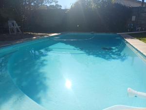 a large blue swimming pool with the sun shining at 7th Heaven Guest Unit in Paarl