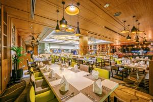 a dining room with tables and chairs in a restaurant at Centara Grand at Central Plaza Ladprao Bangkok in Bangkok
