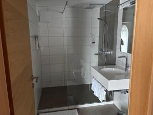 a bathroom with a sink and a shower at Hotel Cafe Lorenz in Hohenems +42 photos