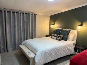 a bedroom with a white bed and a window at The Red Couch Accommodation in Tsumeb