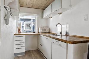 a kitchen with white cabinets and a sink and a window at 13383-Asnaes-Glentevej-15 in Asnæs