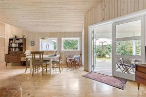 a living room with a table and chairs and a dining room at 10039-Nykobing-Sj-Rishoj-Sidevej-9 in Nakke