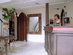 a woman standing at a counter in a salon at Hotel Huys van Heusden in Asten