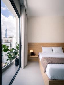 a bedroom with a bed and a large window at Harbor Point Quoc Huong, Thao Dien in Ho Chi Minh City