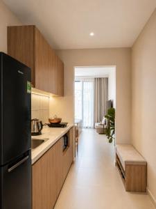 a kitchen with a black refrigerator and a sink at Harbor Point Quoc Huong, Thao Dien in Ho Chi Minh City