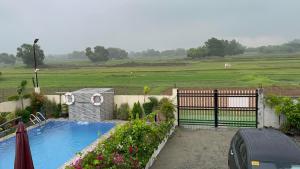 a swimming pool in a yard with a fence and a field at BalaiBesa Transient House in Lingayen