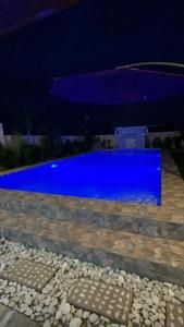 a blue swimming pool at night with a building at BalaiBesa Transient House in Lingayen
