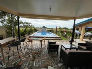 a patio with a pool and tables and chairs at BalaiBesa Transient House in Lingayen