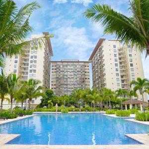 a large swimming pool in front of two large buildings at Alabang Staycation by East Bay Residence in Sampong