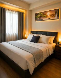 a bedroom with a large bed and a window at Alabang Staycation by East Bay Residence in Sampong +32 photos