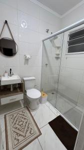 a bathroom with a shower and a toilet and a sink at Apartamento Boqueirão Ilha Comprida Tati Ortega in Ilha Comprida +17 photos