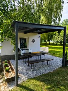 a picnic table under a pavilion in a garden at Glamping Cesty bez kompasu in Horní Jiřetín