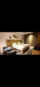 a bedroom with a bed and a table and chairs at فندق أونارا ستاي in Medina