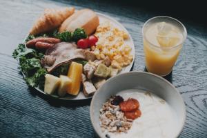 a table with a plate of food and a glass of orange juice at DDD HOTEL in Tokyo