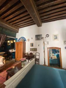 a living room with a table and a mirror at Le Boudoir d'artiste in Semur-en-Auxois