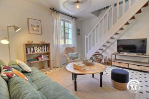 a living room with a green couch and a tv at Le clos kerroux in Noyal-Muzillac