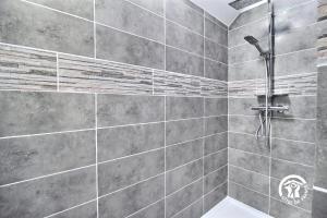 a bathroom with a shower with gray tiles at Le clos kerroux in Noyal-Muzillac +22 photos