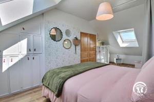 a bedroom with a pink bed and a window at Le clos kerroux in Noyal-Muzillac