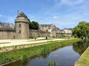 a castle with a river in front of it at Le clos kerroux in Noyal-Muzillac