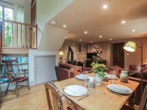 a dining room and living room with a wooden table at The Lodge Farm Barn in Kerne Bridge
