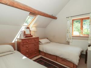 two beds in a small room with a window at The Lodge Farm Barn in Kerne Bridge