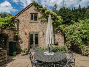 an umbrella sitting on a table in front of a building at The Lodge Farm Barn in Kerne Bridge