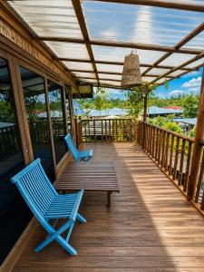 two blue chairs and a bench on a porch at The Secret Sanctuary in Kuching