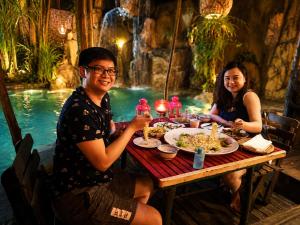 a man and woman sitting at a table with food at The Secret Sanctuary in Kuching
