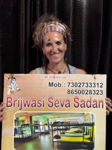 a woman holding a sign in front of a cage at Brijwasi Seva Sadan in Mathura
