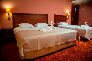 two beds in a hotel room with swans on them at Kelesler Park Hotel in Ereğli