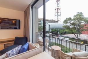 a balcony with a couch and chairs and a large window at Myla Magnolia in Mexico City