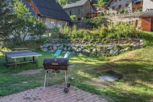 a grill and a ping pong table in a yard at Chalet Rostaing in Vaujany