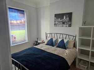 a bedroom with a bed with blue sheets and a window at Marina Bed Liverpool City LFC in Liverpool