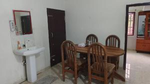 a bathroom with a wooden table and chairs and a sink at Estateview Villa Homestay in Sakleshpur