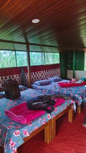 a group of three beds in a room at Estateview Villa Homestay in Sakleshpur