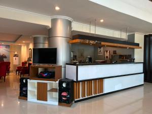 a living room with a tv and a counter at Utc Damhil By Prasanthi in Telaga