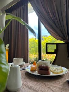 a plate of breakfast food on a table with a window at Villa Verde Guest House in General Santos