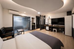 a hotel room with a large bed and a television at Hotel Midas in Daegu